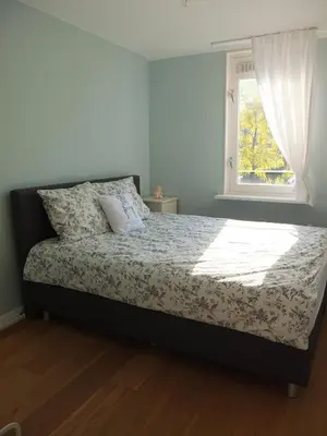 a bedroom with a large bed with a window at Cozy 2 Bedroom Home Away from Home in Amsterdam