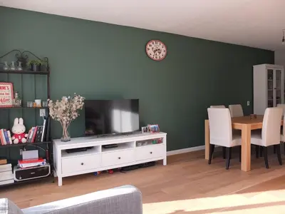 a living room with a television and a table with chairs at Cozy 2 Bedroom Home Away from Home in Amsterdam