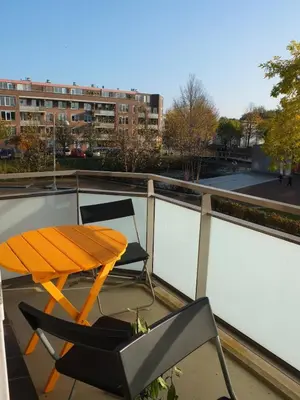 a table and a chair on a balcony at Cozy 2 Bedroom Home Away from Home in Amsterdam