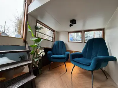 two blue chairs sitting in a small room at Houseboat Avontuur in Amsterdam
