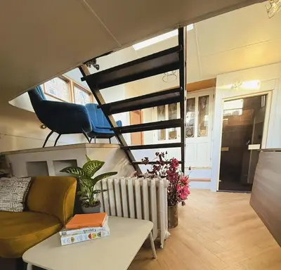 a living room with a couch and a table at Houseboat Avontuur in Amsterdam