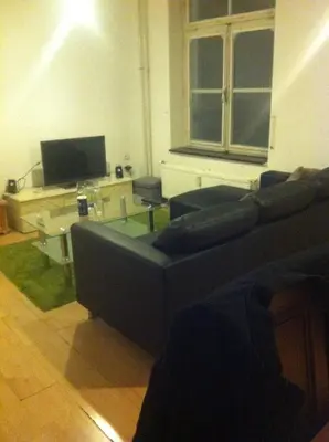 a living room with a couch and a tv at Studio in Ons Belang