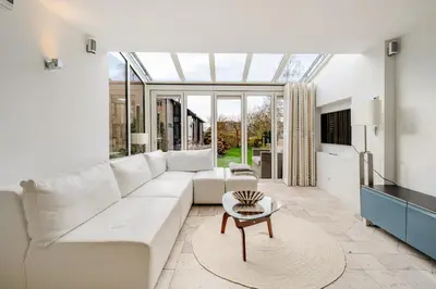 a living room with a white couch and a glass ceiling at Charming Loft with Free Parking and 15 mins to AMS in Vinkeveen