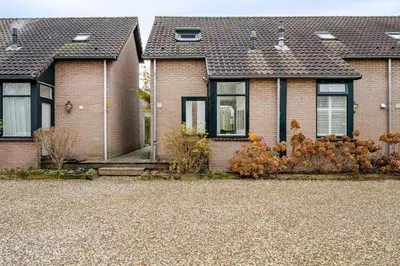 a brick house with black windows and a driveway at Charming Loft with Free Parking and 15 mins to AMS in Vinkeveen