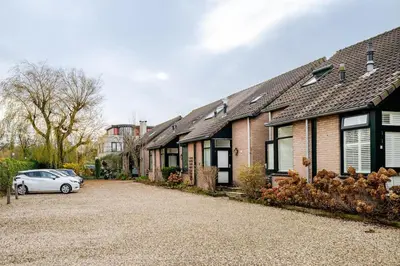 a house with a car parked in the driveway at Charming Loft with Free Parking and 15 mins to AMS in Vinkeveen
