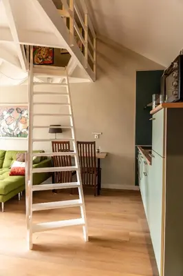 a room with a loft bed and a kitchen at De Stranding Nieuw in Egmond aan den Hoef