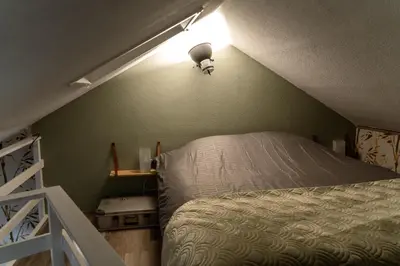 a bedroom with a bed and a light on the wall at De Stranding Nieuw in Egmond aan den Hoef