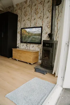 a living room with a television and a wood stove at De Stranding Nieuw in Egmond aan den Hoef