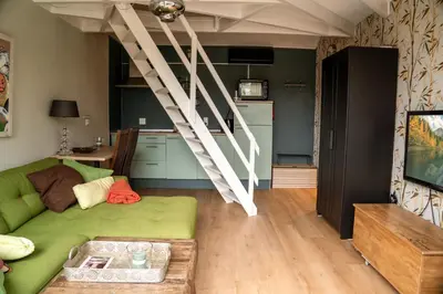 a living room with a green couch and a table at De Stranding Nieuw in Egmond aan den Hoef