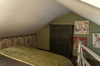 a bedroom with a bed and a cabinet in a attic at De Stranding Nieuw in Egmond aan den Hoef