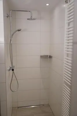 a bathroom with a shower with a glass door at Lighthouse Beach Apartment in Noordwijk aan Zee