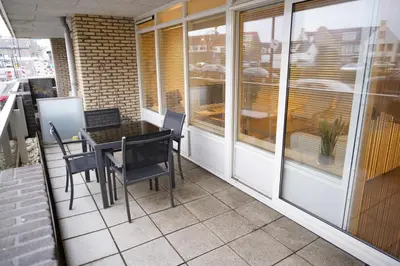 a balcony with a table and chairs on it at Lighthouse Beach Apartment in Noordwijk aan Zee