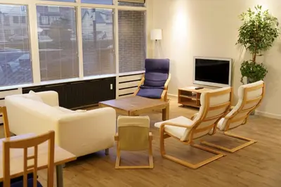 a waiting room with chairs and a tv at Lighthouse Beach Apartment in Noordwijk aan Zee