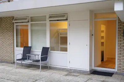 two chairs sitting in front of a building at Lighthouse Beach Apartment in Noordwijk aan Zee