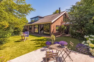 a home with a yard with a table and chairs at Villa Zonnelicht in Bergen