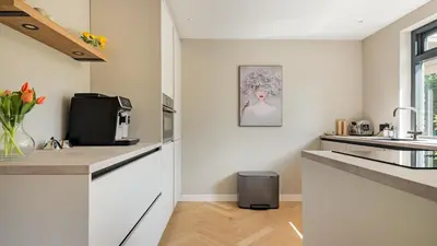 a kitchen with white cabinets and a sink at Villa Zonnelicht in Bergen