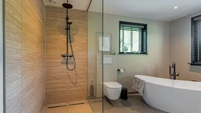 a bathroom with a tub and a toilet and a shower at Villa Zonnelicht in Bergen