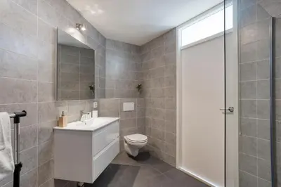 a bathroom with a toilet and a sink and a shower at Comfortable Stay Close To The Coast in Burgerbrug