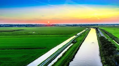 an aerial view of a river in a field at Comfortable Stay Close To The Coast in Burgerbrug