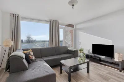 a living room with a couch and a flat screen tv at Comfortable Stay Close To The Coast in Burgerbrug
