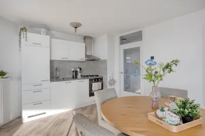 a kitchen with a wooden table and white cabinets at Comfortable Stay Close To The Coast in Burgerbrug