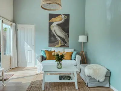 a living room with a bird painting on the wall at The Pelican in Warmenhuizen