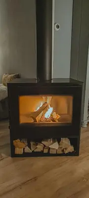 a fireplace with a fire in it in a room at The Pelican in Warmenhuizen