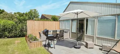 a patio with a table and an umbrella at The Pelican in Warmenhuizen
