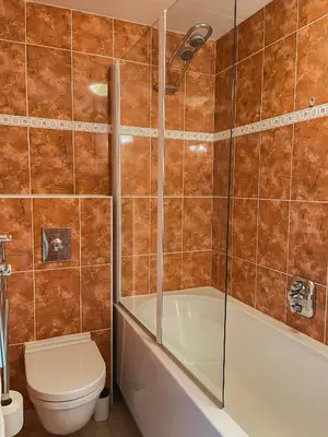 a bathroom with a tub and a toilet and a shower at The Pelican in Warmenhuizen