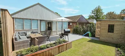 a backyard with a couch and an umbrella at The Pelican in Warmenhuizen