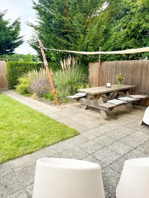 a picnic table and a hammock in a garden at Strandbries in Warmenhuizen
