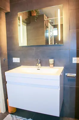 a bathroom with a white sink and a mirror at Strandbries in Warmenhuizen