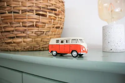 a small red and white toy van sitting on a table at Strandbries in Warmenhuizen