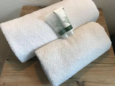 two towels on a table with a bottle of soap at Villa Yburg in Amsterdam