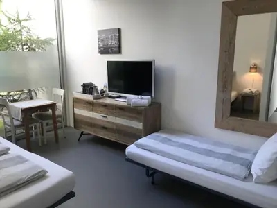 a bedroom with a television and a dresser with a mirror at Villa Yburg in Amsterdam