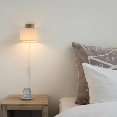 a lamp on a table next to a bed at Villa Yburg in Amsterdam