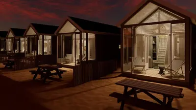 a row of houses with benches on a deck at Skip Inn Strandhuisjes in Katwijk aan Zee