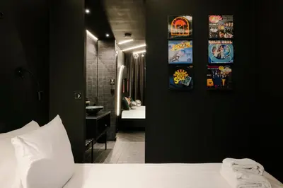 a bedroom with a bed and a bathroom with posters on the wall at Supper Boutique Suites in Amsterdam