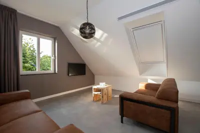 a living room with two couches and a window at Hotelboerderij Akkerlust in Leidschendam