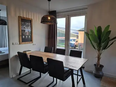 a dining room with a wooden table and chairs at Hotelboerderij Akkerlust in Leidschendam