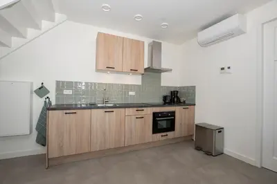 a kitchen with wooden cabinets and a sink at Hotelboerderij Akkerlust in Leidschendam