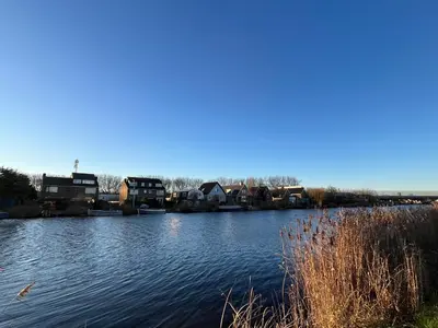 a view of a river with houses and buildings at Cosy Garden Room Riverhouse in Ouderkerk aan de Amstel