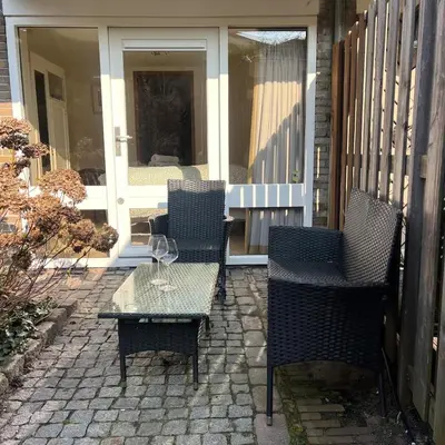 three chairs and a table on a patio at Cosy Garden Room Riverhouse in Ouderkerk aan de Amstel