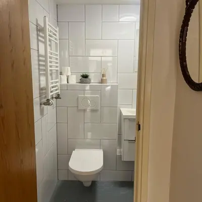 a white bathroom with a toilet and a sink at Cosy Garden Room Riverhouse in Ouderkerk aan de Amstel