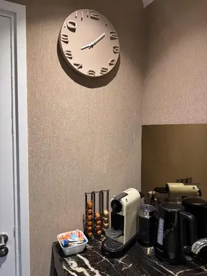 a clock hanging on a wall above a coffee maker at Stylish apartment near Amsterdam in Badhoevedorp