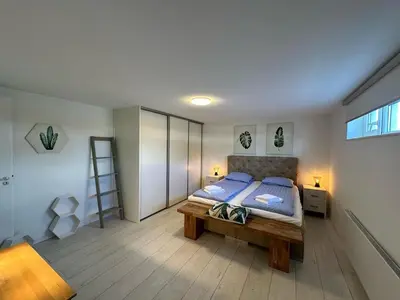 a bedroom with a bed and a ladder in it at Houseboat the Otter incl free boat and supboards in Loosdrecht