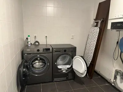 a bathroom with a washing machine and a toilet at Houseboat the Otter incl free boat and supboards in Loosdrecht