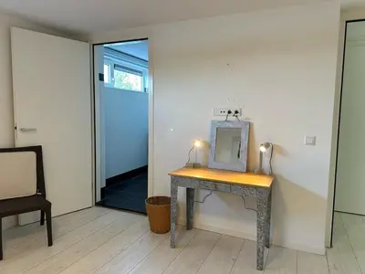 a dressing table with a mirror on it next to a door at Houseboat the Otter incl free boat and supboards in Loosdrecht