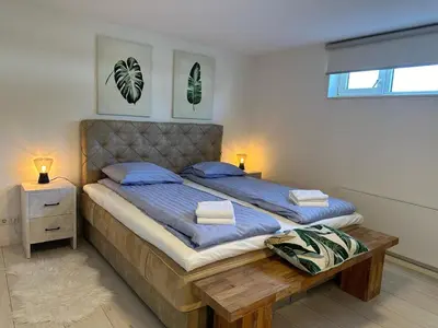 a bedroom with a large bed with a wooden table at Houseboat the Otter incl free boat and supboards in Loosdrecht