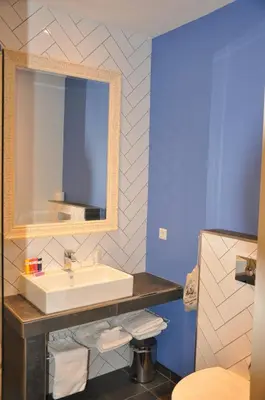 a bathroom with a sink and a mirror at Hotel Rauw aan de Kade in IJmuiden
